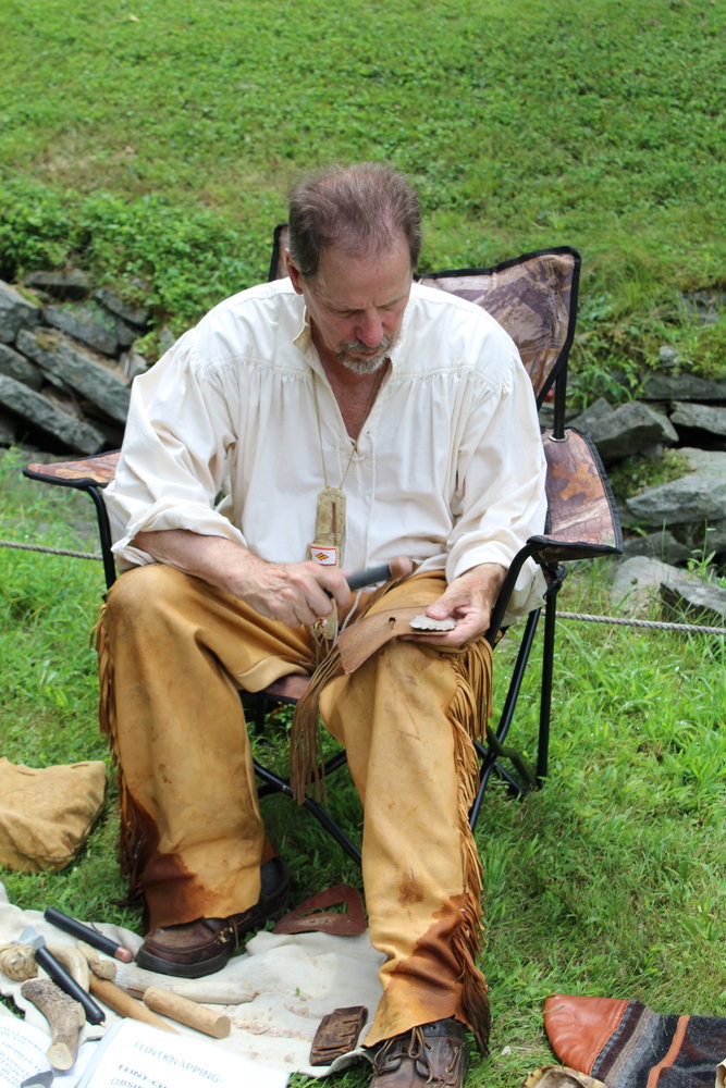 Ed Burgholzer demonstrates flintknapping at the August 21 Canal Fest. The finished flint can become an arrowhead or a knife.